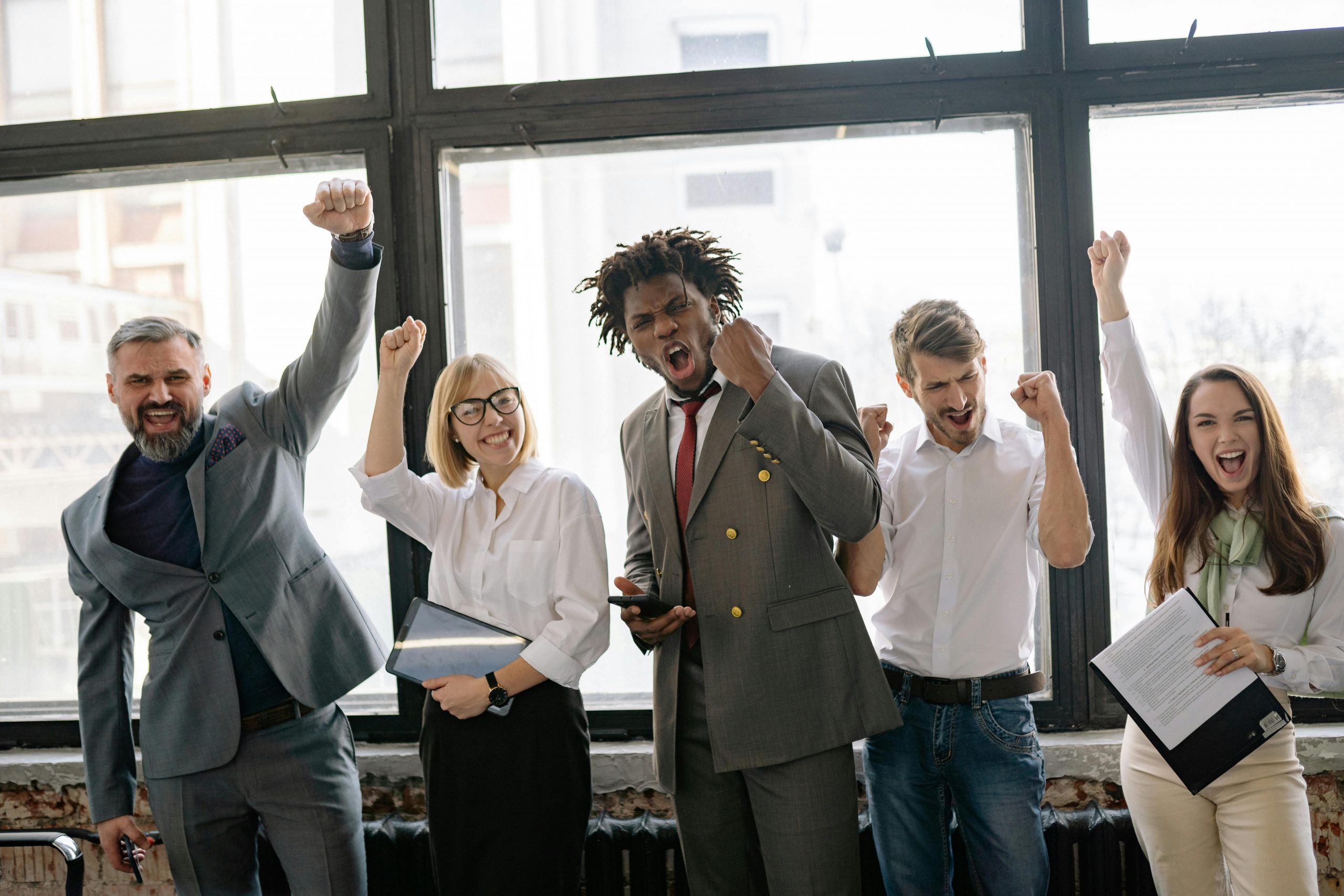 happy employees standing by a large window