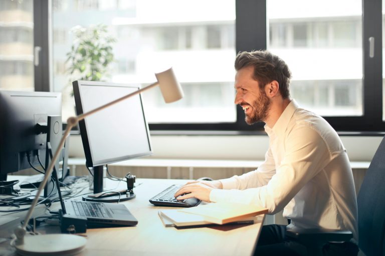 professionally dressed man working on an office computer